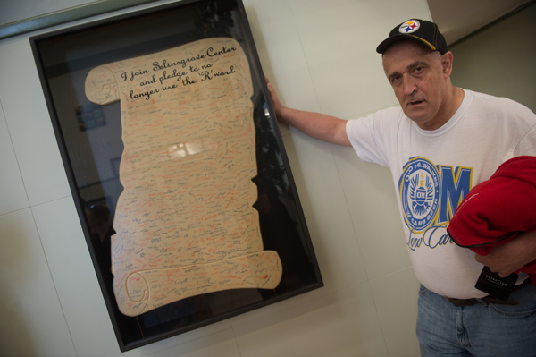 Jim C. stands next to poster with signatures