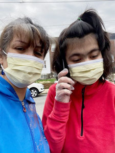 Mansoureh and Arina pose close together wearing masks