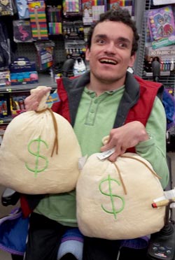 Robert in a store holding 2 novelty money bags