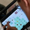 Person taps screen of AAC app