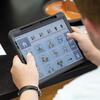 Young man uses app with pictures and words on a tablet for augmentative and alternative communication