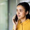 Young parent talking on their mobile phone with a worried expression