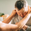 caregiver adjusts clothing of older adult with Down Syndrome