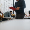 A half dozen professionals of mixed abilities work around a shared table
