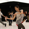 Dancer looks over own shoulder while moving among others
