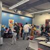 people of mixed abilities mingle at an art opening